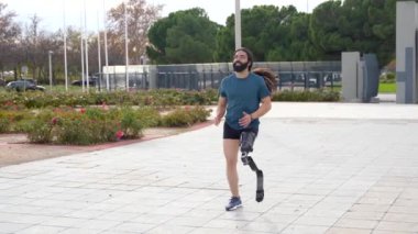 Şehir parkında çalışan protez bacaklı fiziksel engelli bir adam.