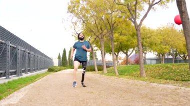 Parkta protez bacakla koşan engelli bir sporcunun fotokopi alanı ile düşük açı görüntüsü