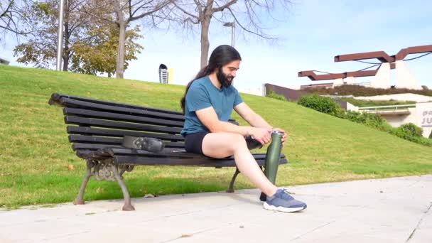 Amputee Αθλητής Προσαρμογή Τεχνητό Πόδι Του Τρέχει Κάθεται Ένα Παγκάκι — Αρχείο Βίντεο
