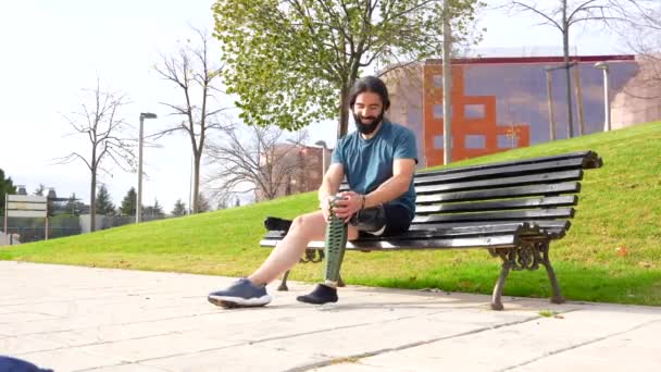 Fizycznie Niepełnosprawny Mężczyzna Regulujący Protezę Nogi Przed Bieganiem Miejskiej Ławce — Wideo stockowe