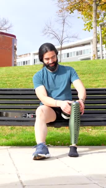 Fiziksel Engelli Erkek Koşucu Parkta Bir Bankta Oturarak Protez Bacağını — Stok video