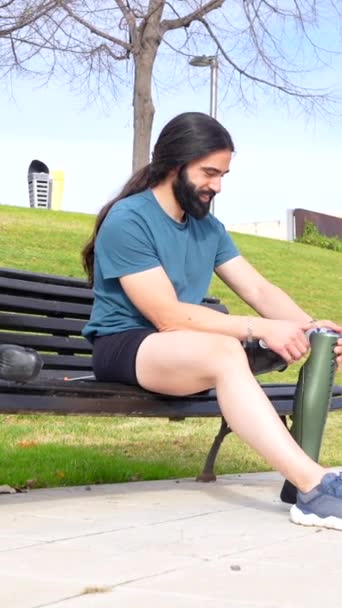 Atlet Pembantu Menyesuaikan Kaki Buatannya Dengan Duduk Bangku Taman — Stok Video