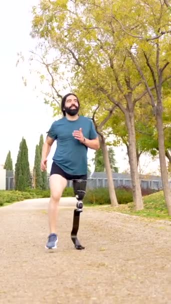 公園で義足で走っている障害のある運動選手のコピースペースを備えた低角度ビデオ — ストック動画