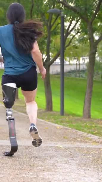 一个有假腿的运动员沿着公园跑步的后视镜 — 图库视频影像