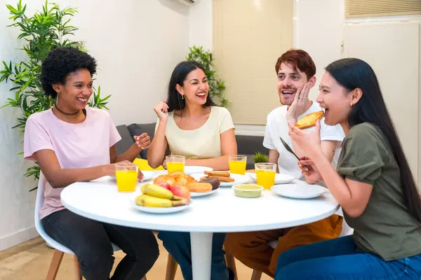 Domestic scene of multi-ethnic friends eating delicious breakfast together at home