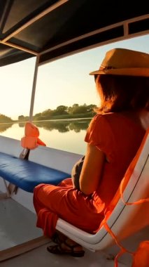 Shiroka 'daki Shkoder Gölü' nde turist gezisi yapan bir teknede turist bir kadın. Arnavutluk