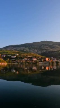 Geleneksel bir tekneyle Shkoder 'den gezintiye çıkmış Shiroka şehrinin göl manzarası. Arnavutluk