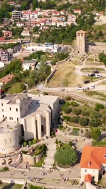 Kruje Kalesi ve kalesi hava aracı, kule ve arkasında dağlar olan Kruje müzesinden görüldü. Arnavutluk. Döndürme