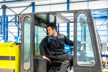 Modern bir Cnc lojistik fabrikasında forklift kullanan bir işçi.