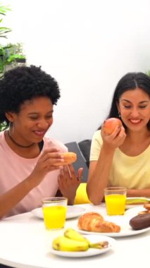 Mutlu çok ırklı arkadaşlar kahvaltıda kutlama yapıp beşlik çakıyorlar.