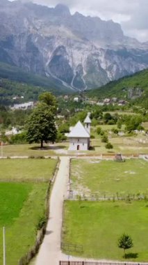 Arnavutluk 'un Theth Ulusal Parkı vadisindeki Katolik Kilisesi' ne doğru dönüyor. Alp Dağları