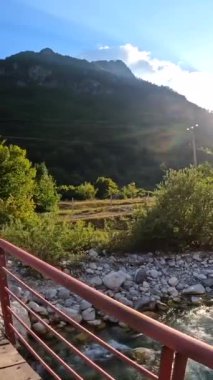 Valbona Vadisi, Theth Ulusal Parkı, Arnavutluk Alpleri, Arnavutluk 'un turkuaz su nehri üzerindeki kırmızı köprüde gün batımı