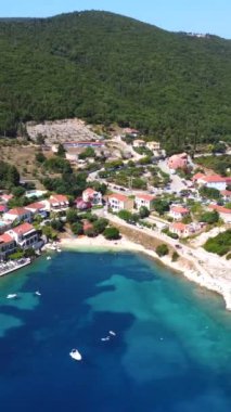 Yunanistan 'ın Kefalonia adasındaki Fiskardo köyünün limanındaki küçük bir plajın yazın havadan görünüşü