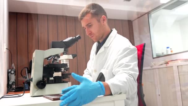 Doktor Bir Hastanenin Laboratuarında Numune Mikroskop Kullanarak Tıbbi Araştırma Yapıyor — Stok video
