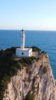 Lefkada adasının güney bölgesinde gün batımında beyaz deniz feneri veya Cape Ducato Lefkas 'ın insansız hava aracı görüntüsü. Yunanistan. Dönen pan düzlemi