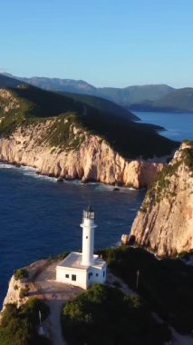 Uçurumların ve beyaz deniz fenerinin hava aracı görüntüsü ya da Lefkada adasının güney bölgesinde gün batımında Ducato Lefkas Burnu. Yunanistan. Uçağı yakınlaştır