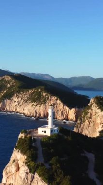 Uçurumların ve beyaz deniz fenerinin hava aracı görüntüsü ya da Lefkada adasının güney bölgesinde gün batımında Ducato Lefkas Burnu. Yunanistan. Uçağı yakınlaştır