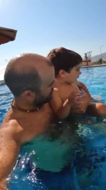 Aile ve oğul yazın havuzda tatilin tadını çıkarıyorlar.