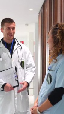 Hastane koridorunda konuşan bir kadın hemşire ve doktorun ekip çalışması.