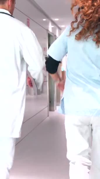 在医院走廊里谈话的一名女护士和一名女医生的团队工作 — 图库视频影像