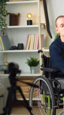 Evinde tekerlekli sandalyede oturan mutlu engelli bir adamın portresi.