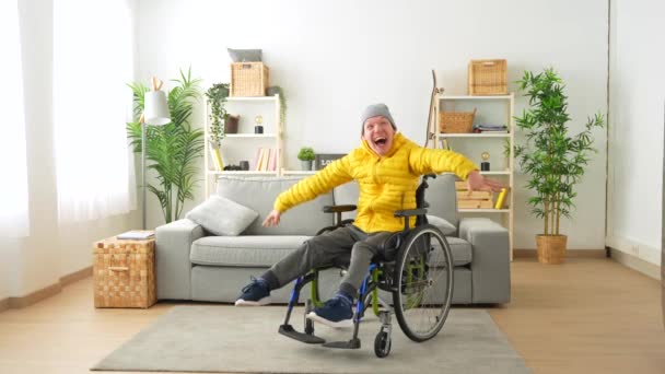 リビングルームに車椅子を使用した暖かい服を着たハッピーな障害者のコピースペース — ストック動画