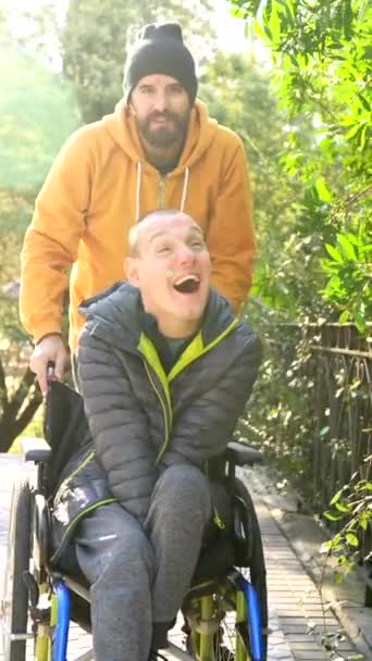 先に都市公園で障害者と話すことを指す介護者 — ストック動画