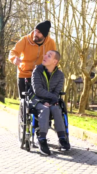 先に都市公園で障害者と話すことを指す介護者 — ストック動画