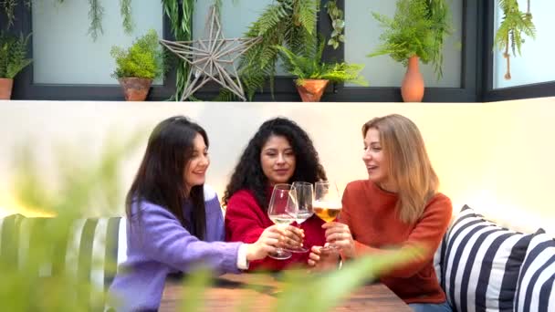 三位女性朋友坐在一家五颜六色的现代自助餐厅里 用白葡萄酒祝酒 — 图库视频影像
