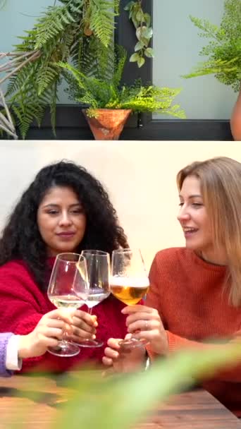 三位女性朋友坐在一家五颜六色的现代自助餐厅里 用白葡萄酒祝酒 — 图库视频影像
