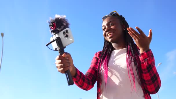 非洲妇女在户外用手机和话筒发微博时挥手 — 图库视频影像