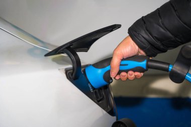 Elektrikli araba şarjlı bir adamın eli.
