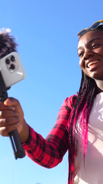 Afrykańska Kobieta Macha Podczas Vlogging Pomocą Telefonu Komórkowego Mikrofonu Zewnątrz — Wideo stockowe