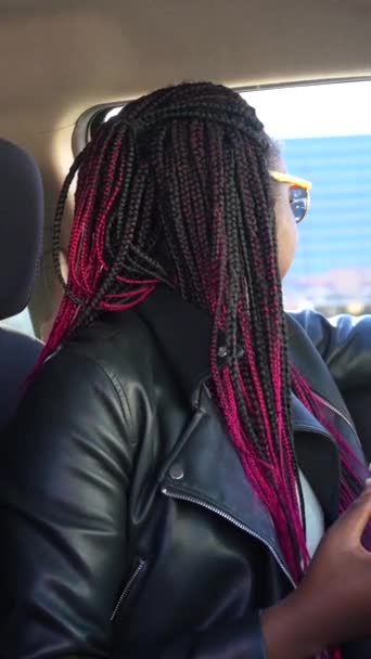 一个快乐的非洲女人坐在车里 从车里看到一个五颜六色的甜甜圈 — 图库视频影像