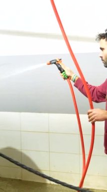 Kafkasyalı sıradan bir adam hidroterapi merkezinde bir atı suyla yıkıyor.