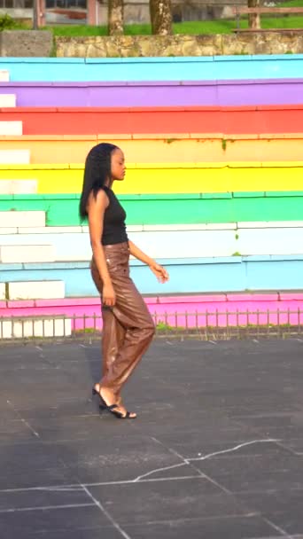 一个自信的年轻非洲女子沿着一个五彩缤纷的楼梯走在城市公园的垂直录像 — 图库视频影像