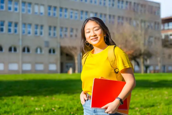 Portrait of a Chinese university student smiling at camera standing in the campus