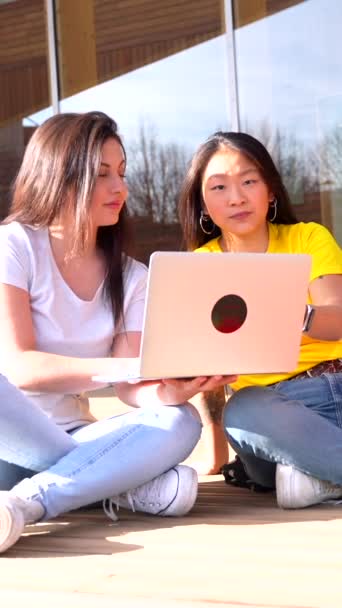 Dwóch Wieloetnicznych Wesołych Młodych Studentów Korzystających Laptopa Siedzącego Kampusie Słoneczny — Wideo stockowe