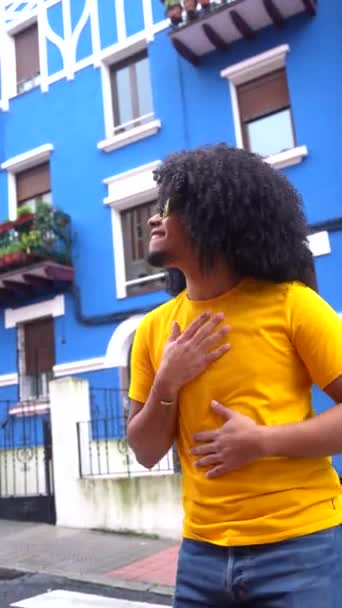 Вертикальное Фото Африканского Юноши Слушающего Музыку Наушниках Улице Рядом Синим — стоковое видео