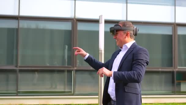 Geschäftsmann Gestikuliert Mit Innovativer Augmented Reality Brille Einem Finanzkomplex — Stockvideo