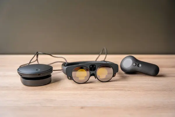 Close-up of a futuristic mixed reality goggles and remote control on a wooden table