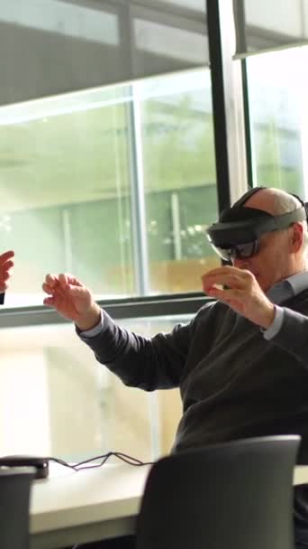 Стареющий Менеджер Сидит Использует Очки Виртуальной Реальности Рядом Сотрудником Офисе — стоковое видео