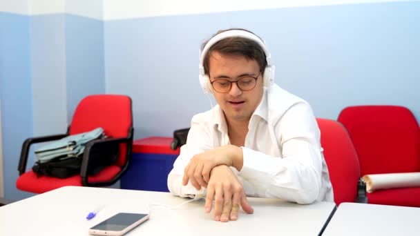 Mand Med Ned Syndrom Lytter Til Musik Med Telefoner Sidder – Stock-video