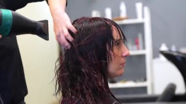 Bir müşterinin saçını kurutmak için saç kurutma makinesi kullanan isimsiz bir kuaförün profil fotoğrafı.
