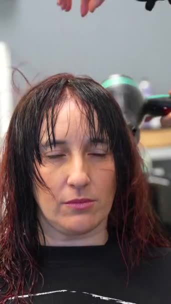 Фронтальное Видео Серьезной Терпеливой Женщины Сидящей Парикмахерской Парикмахер Сушит Волосы — стоковое видео