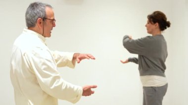 Qi Gong eğitmeni ve kadınlar kapalı bir derste gözlerini ve nefeslerini tutarlar.