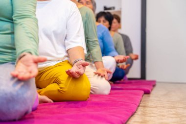 Kopyalama alanı olan kesilmiş fotoğraf ve sırada oturmuş meditasyon yapan insanların ellerine odaklan.