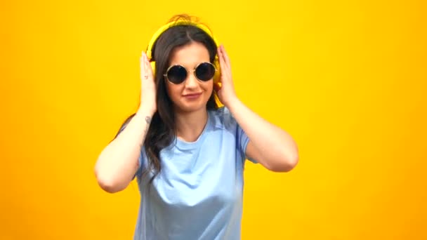 Stüdyo Portresi Sarı Arka Planda Boynunda Güneş Gözlüğü Kulaklıkla Dans — Stok video