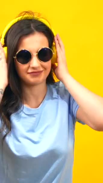 선글라스와 헤드폰을 여자의 노란색 스튜디오 초상화 — 비디오