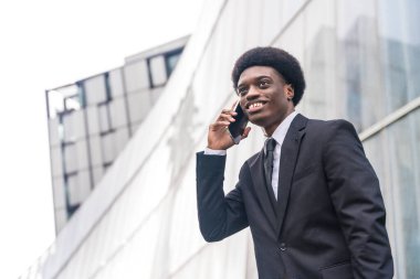 Şehirdeki telefon kullanan Afrikalı bir iş adamının fotokopi çekilen düşük açılı portresi.